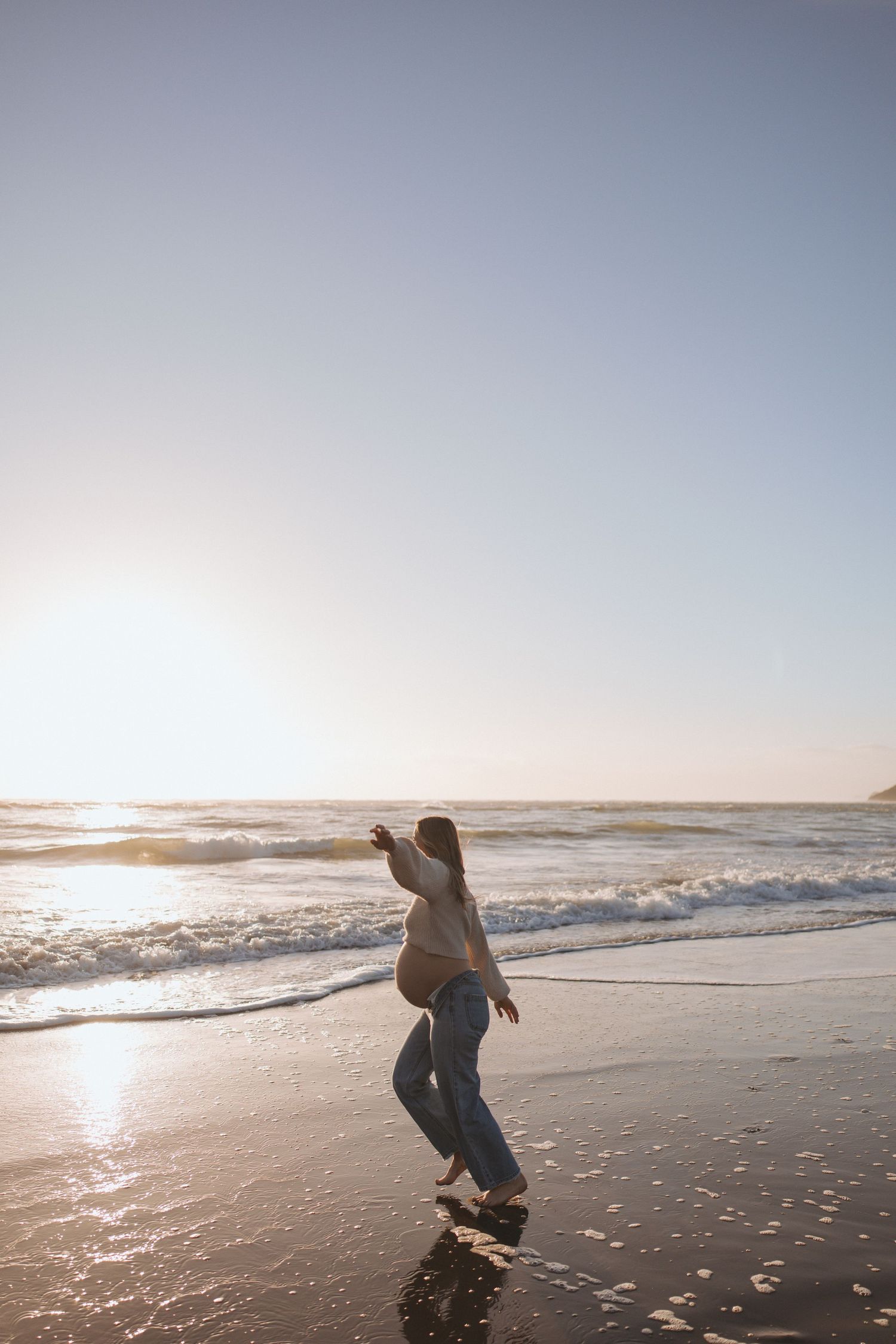 Blurry black and white photo of a person on a beach at sunset, captured with motion blur effect.