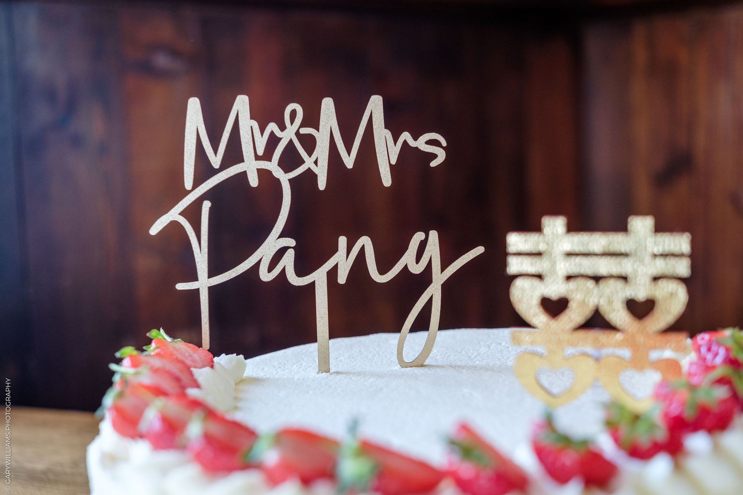 Wedding cake with Mr & Mrs Pang cake topper, decorated with fresh strawberries and gold double happiness symbol.