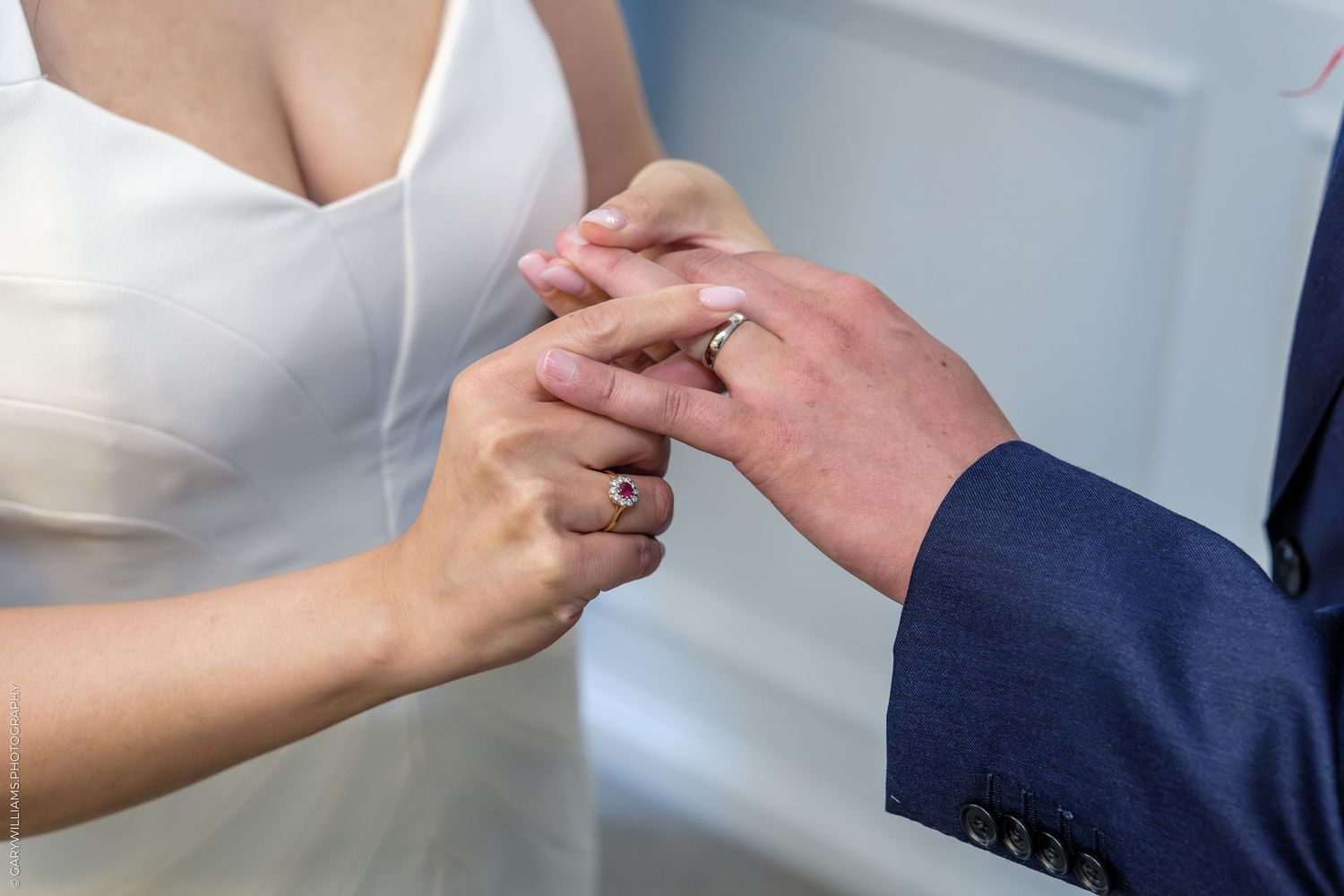 Close-up of bride and groom exchanging wedding rings during ceremony.