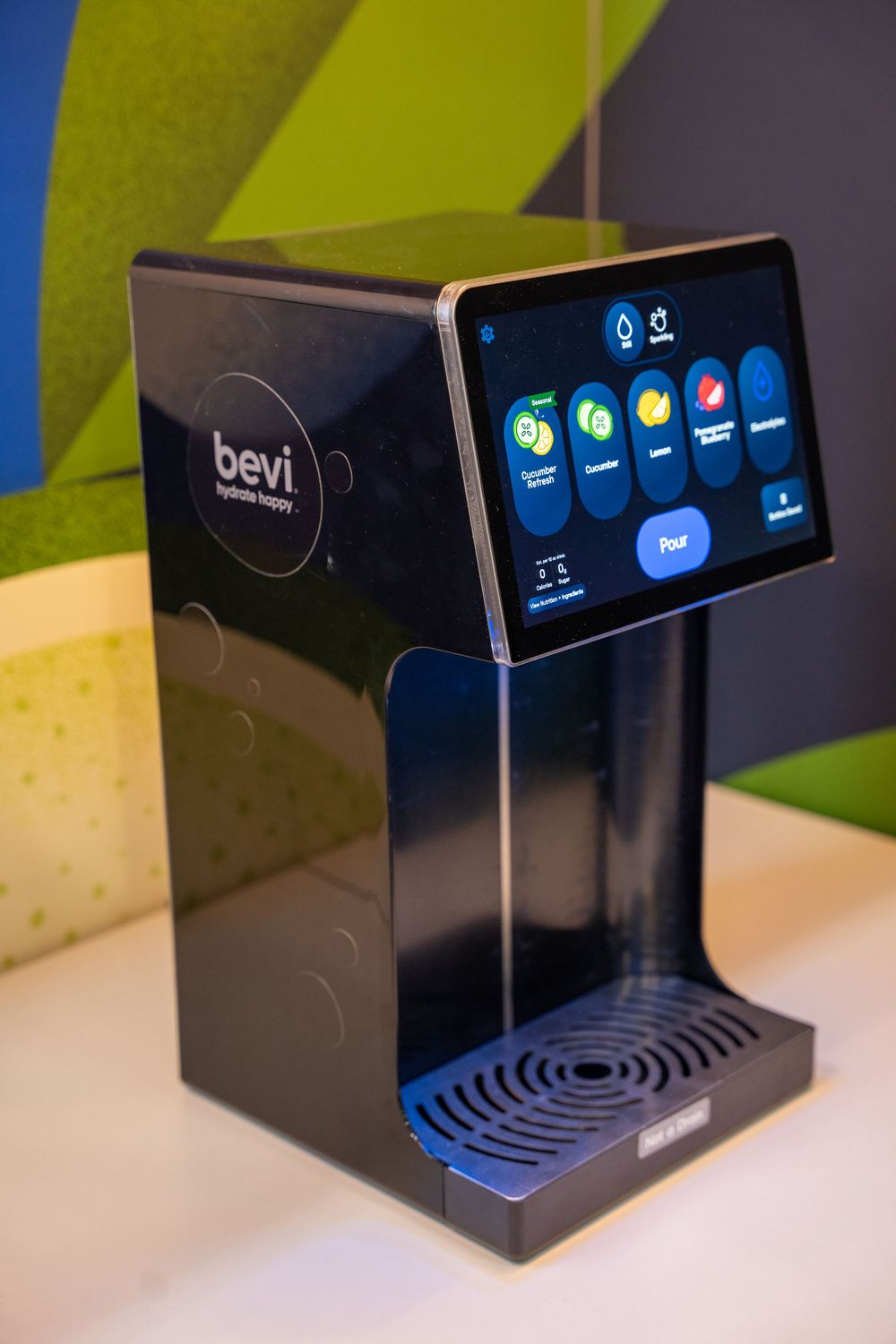 Bevi smart water dispenser with touchscreen interface showing flavored water options on a white countertop.