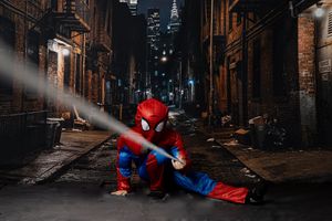 Person in Spider-Man costume crouching in a dark urban alley at night, shooting web in a cinematic city scene.