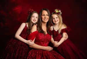 Family portrait series in burgundy dresses against dark background showing loving embraces and joyful moments.