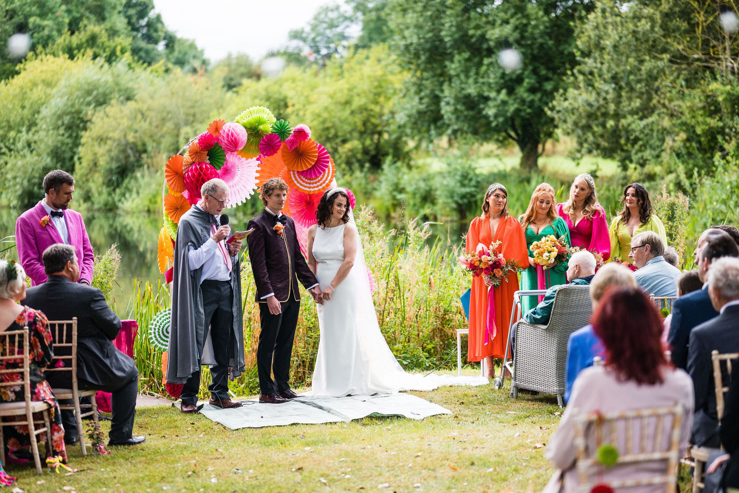 Emma and Tom during their colourful DIY summer garden wedding ceremony