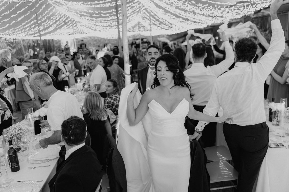 Gli sposi e gli invitati ballano insieme, in bianco e nero.