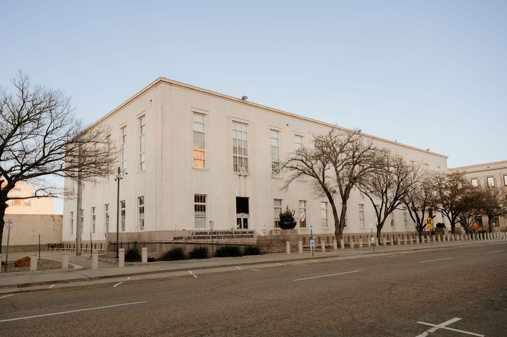 White government building with bare trees lining an empty street at dusk in a small town.