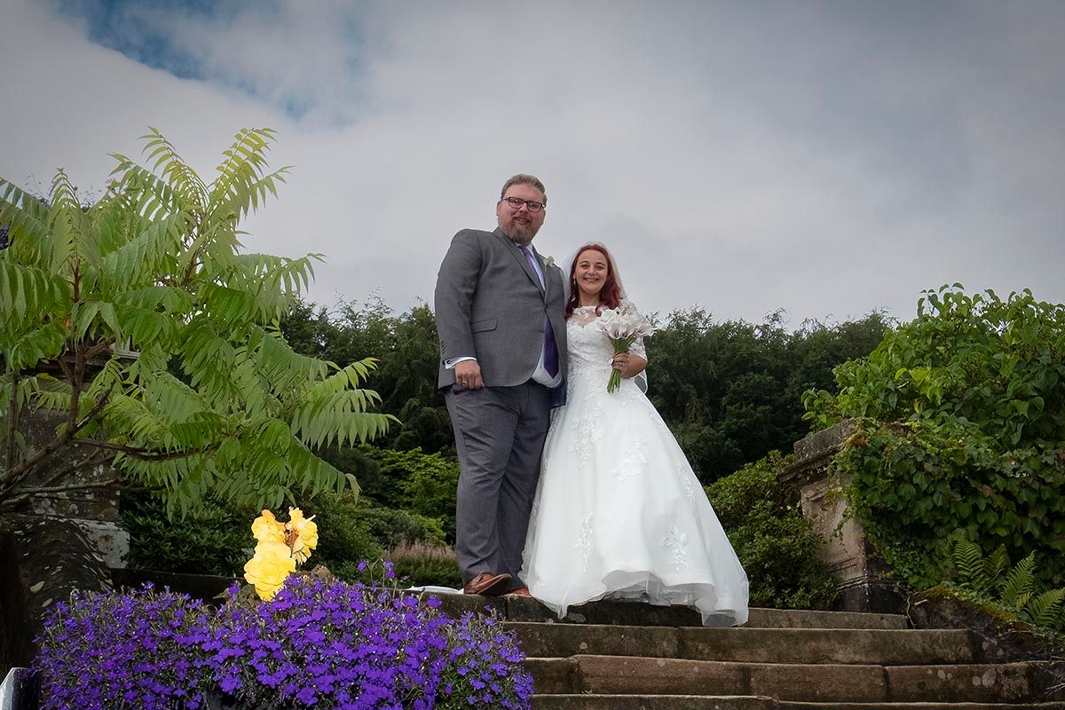 Bride and groom together on the stone steps at Auchen Castle, Dumfriesshire