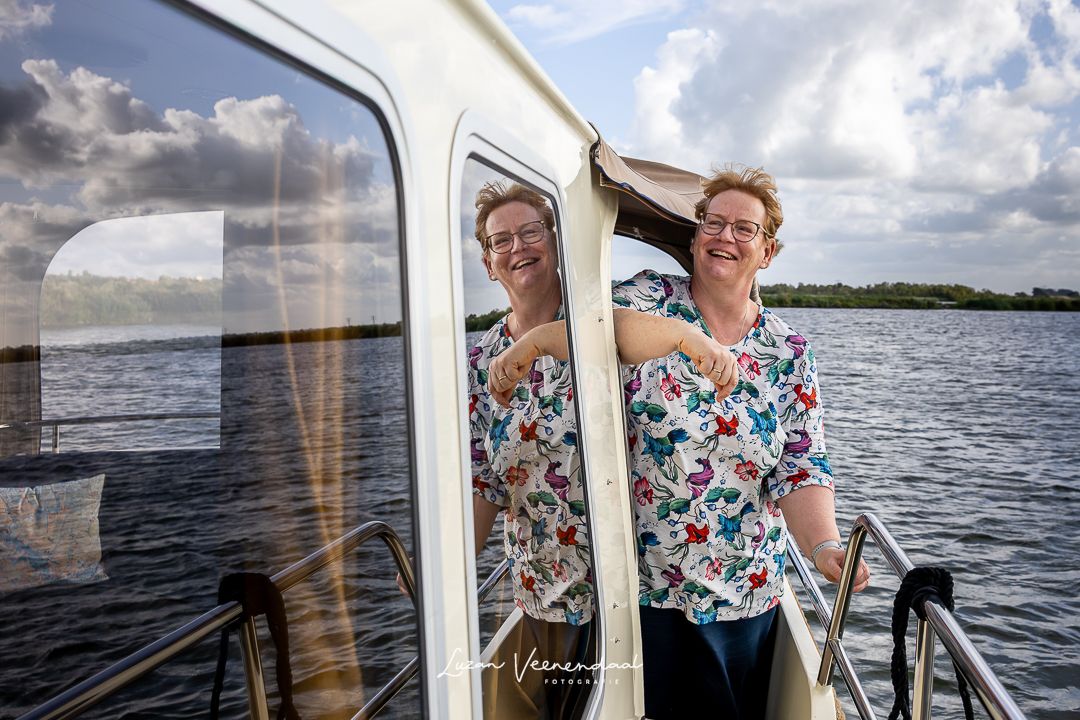 Spiegelbeeld van moeder in het raampje van de boot tijdens een familiefotoshoot op het Uitgeestermeer"