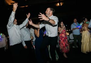 Guests dancing and celebrating at a lively wedding reception party on the dance floor.