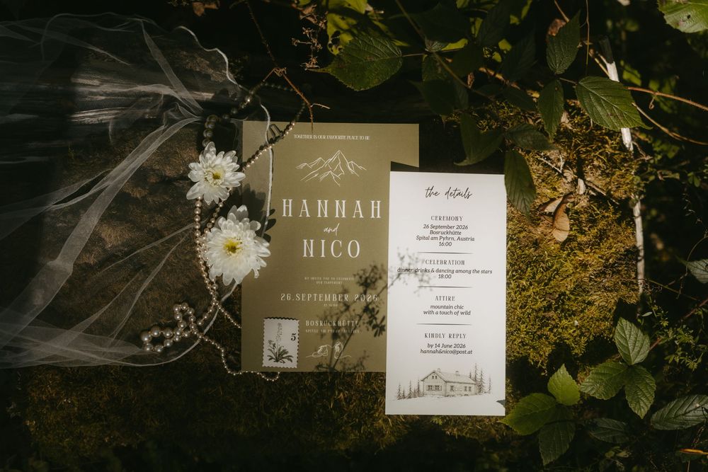 Rustic wedding stationery with olive green invitations for Hannah and Nico displayed on moss with white flowers and a veil.