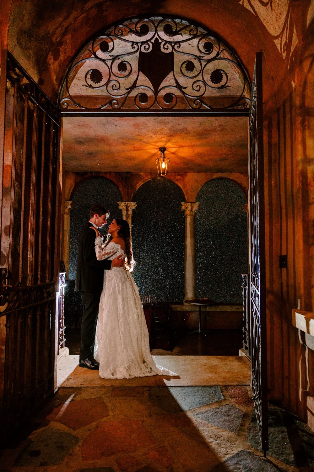 Bride and Groom embracing in the rain, backlit at the Howie Mansion in Florida