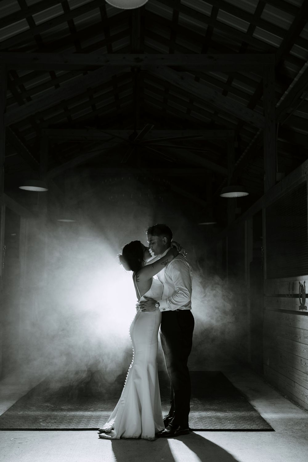 Brida and groom in barn at Ranch 22 in Lake Worth, backlit with fog around them for dramatic picture