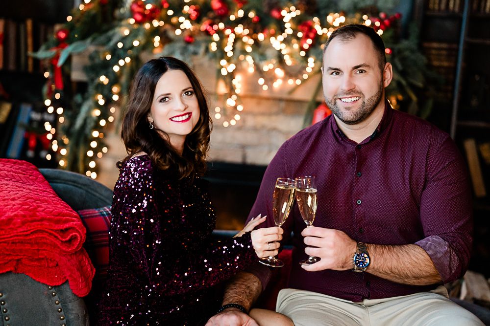 karácsonyi fotózás, páros
Couple toasting champagne glasses by a decorated Christmas tree with festive lights in a holiday portrait.