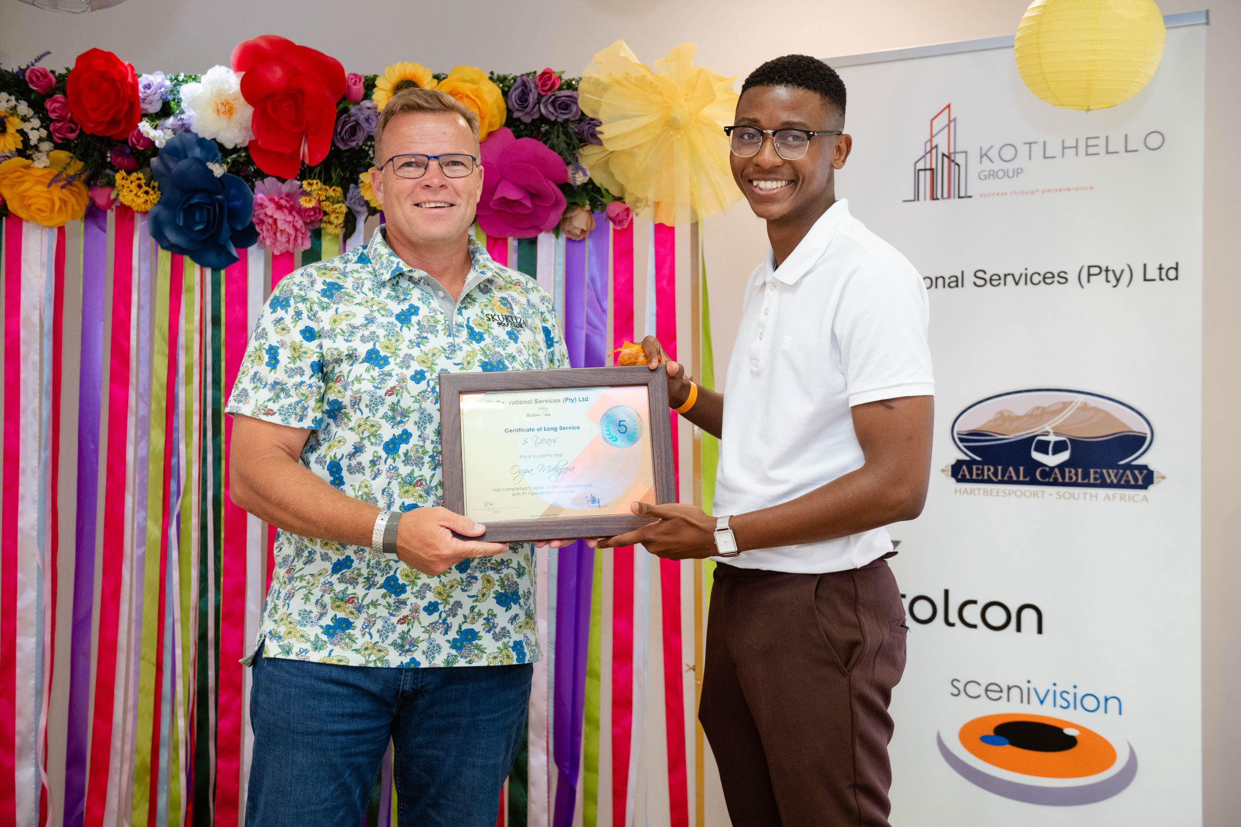 Award recipient proudly posing with a certificate at a corporate awards ceremony.