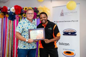 Award recipient proudly displaying a certificate during a corporate awards event.