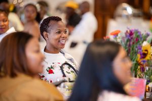 Candid moment of a guest smiling during a colourful awards celebration.
