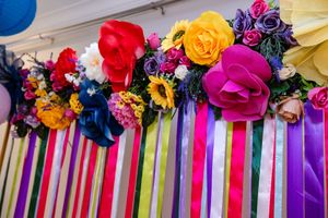 Bold floral arrangement and colourful ribbon backdrop creating a vibrant setting for an awards event.