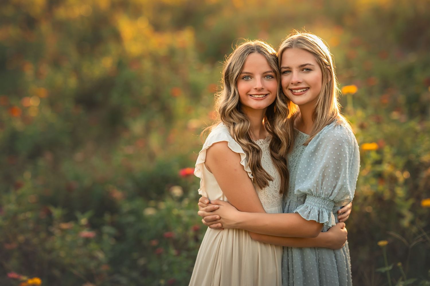 Couple embracing in a vibrant flower garden with red and orange blooms at golden hour.