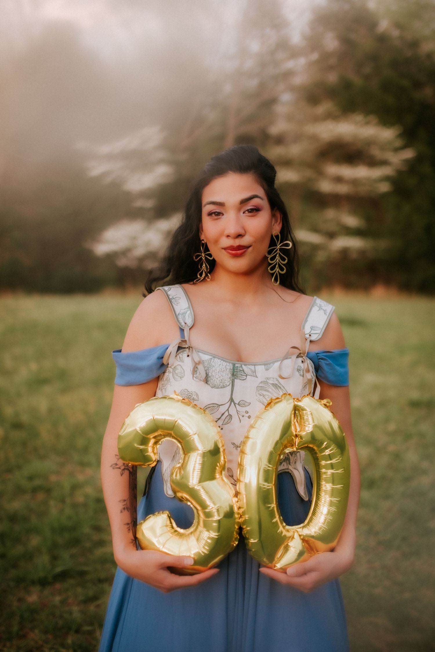 Birthday Portrait of woman holding balloons, trees with florals, golden hour, blue dress, Clarksville Tennessee. Portrait Photogher
