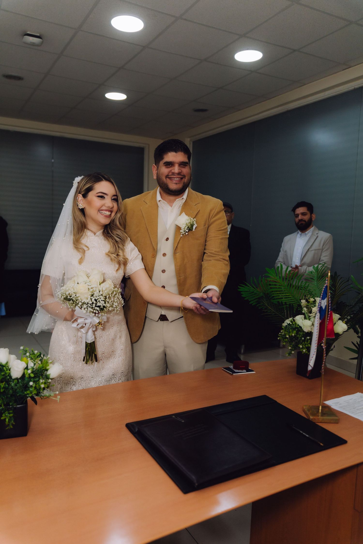 Happy couple posing after signing marriage documents at civil ceremony in Chile.