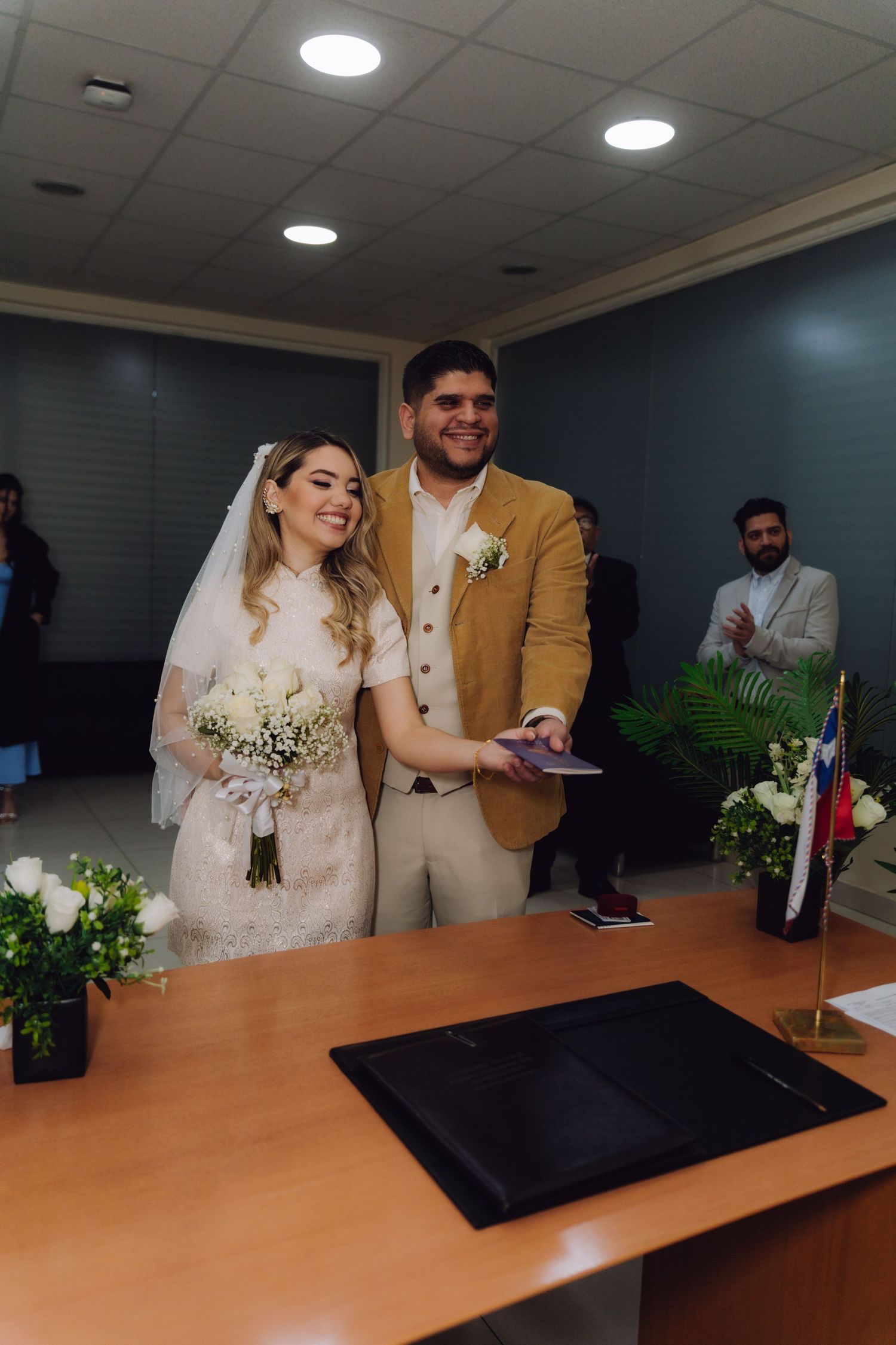 Bride and groom smiling together holding documents after civil wedding ceremony.