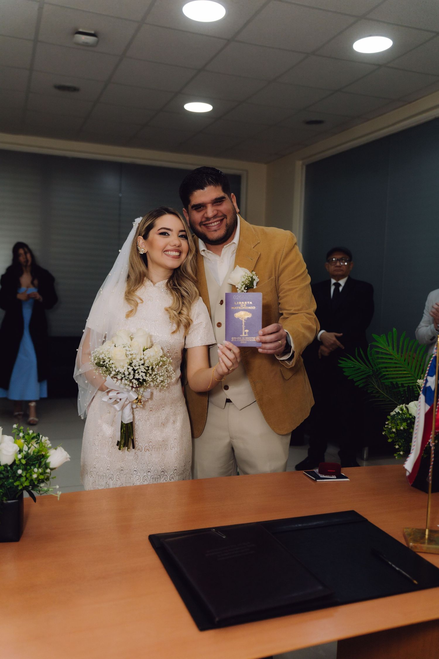 Newlyweds proudly displaying their marriage certificate at civil ceremony.