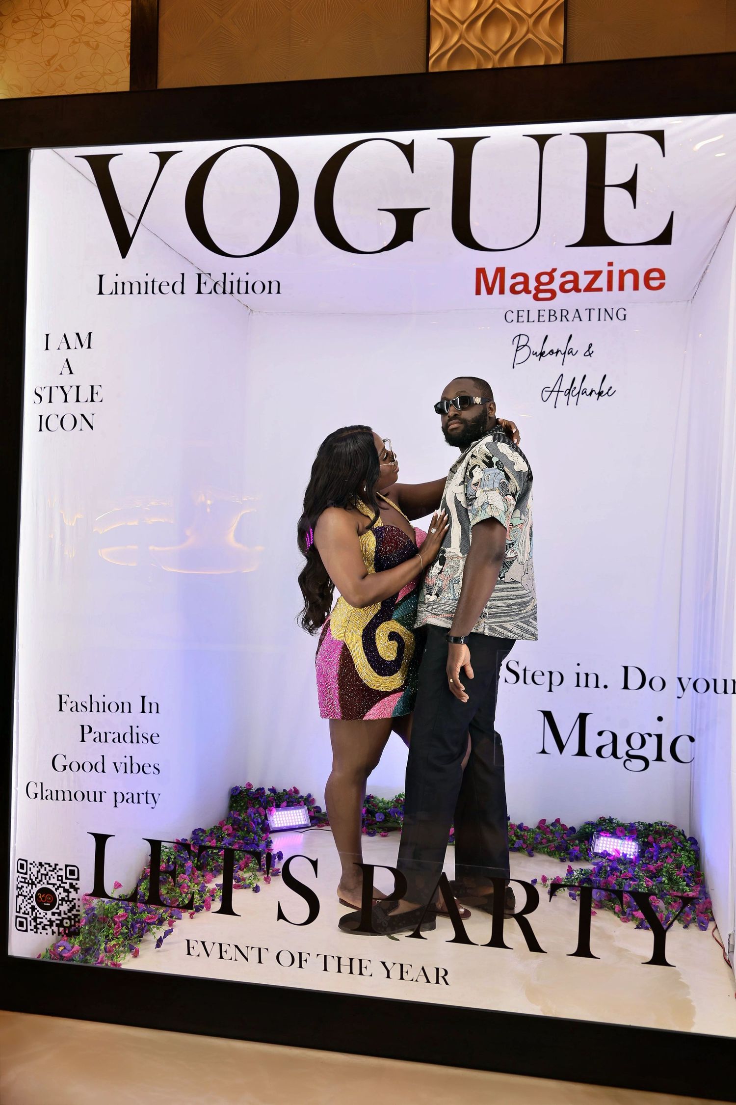 Couple interacting playfully inside a Vogue Magazine Limited Edition Let's Party event photo booth.
