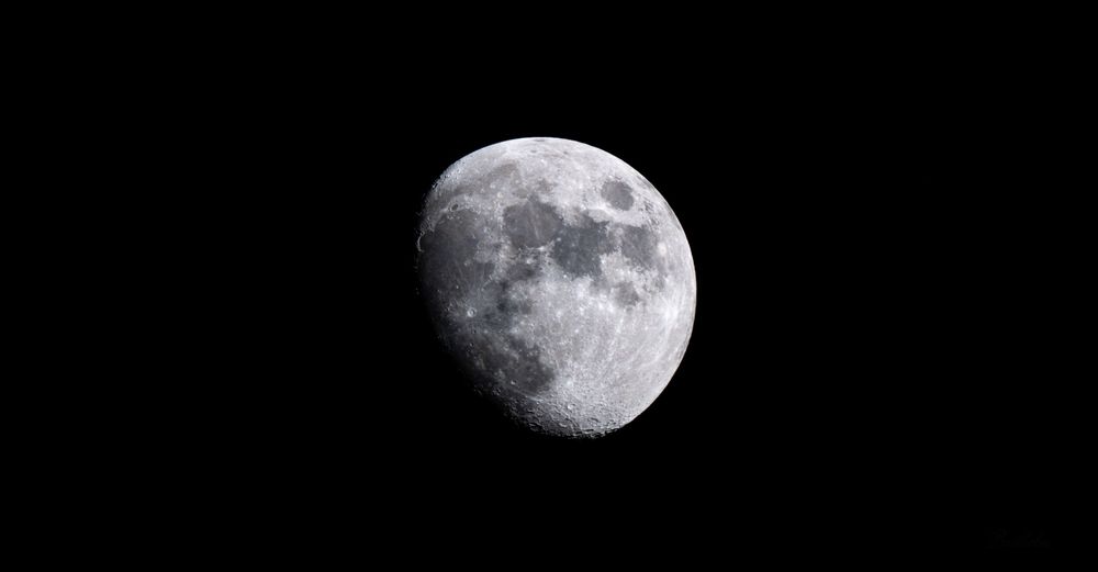 A detailed waxing gibbous moon with visible craters against a black night sky.
