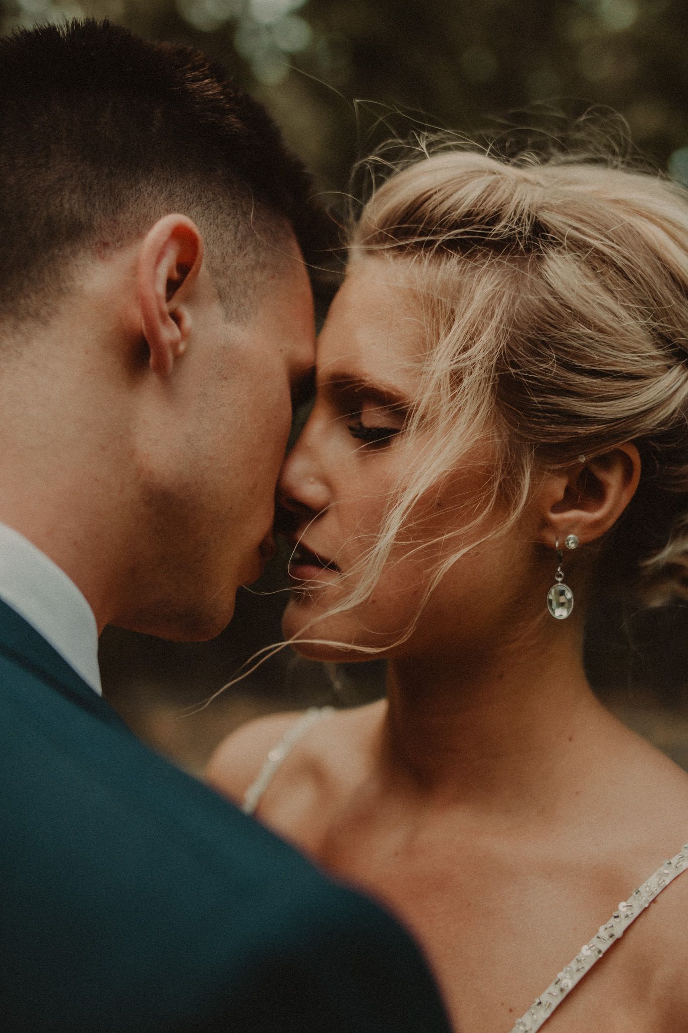 Romantic close-up portrait of a couple sharing an intimate moment in warm natural lighting.