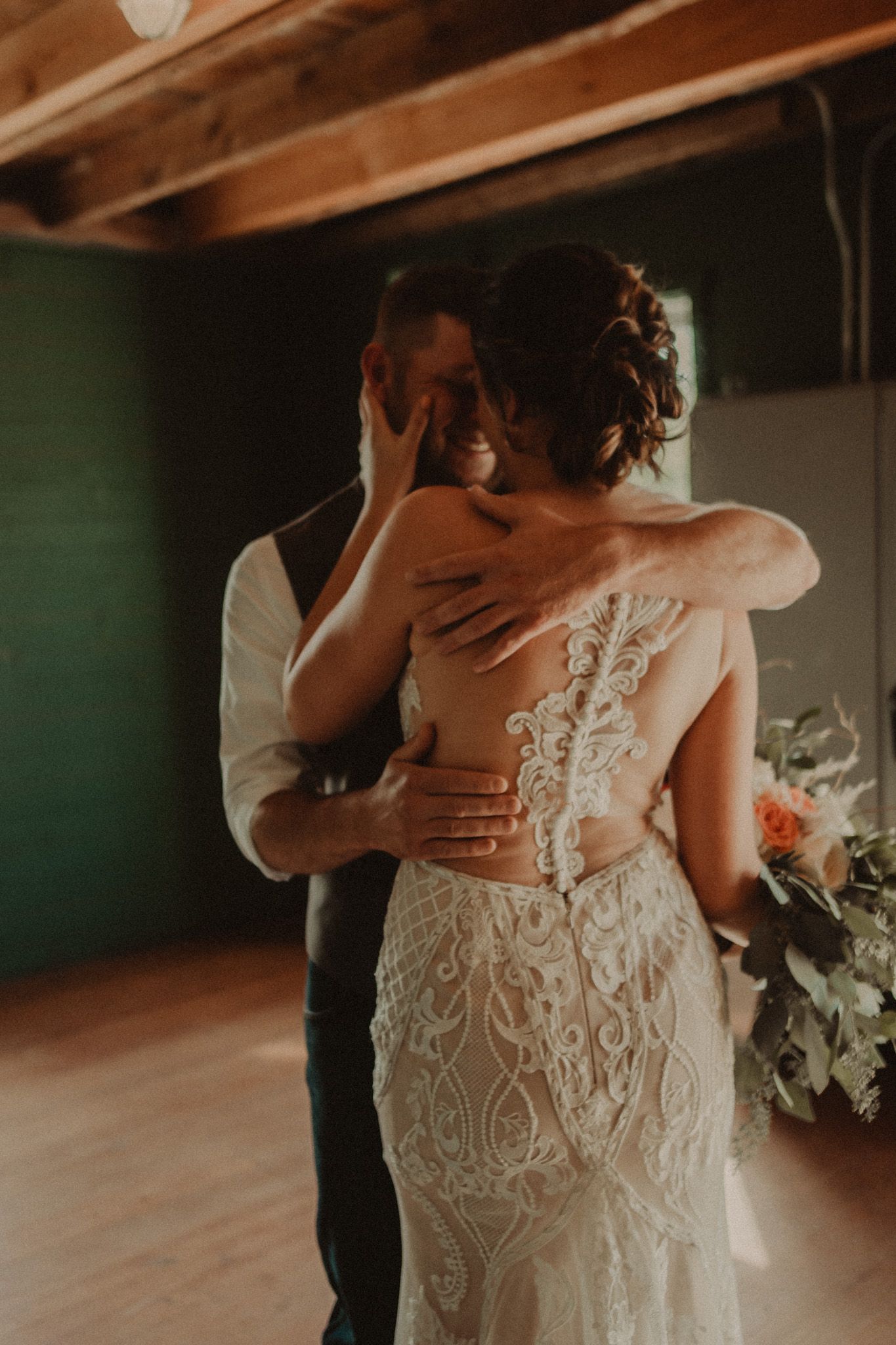 An intimate moment captured between a couple dancing, showcasing the bride's detailed lace back wedding dress.