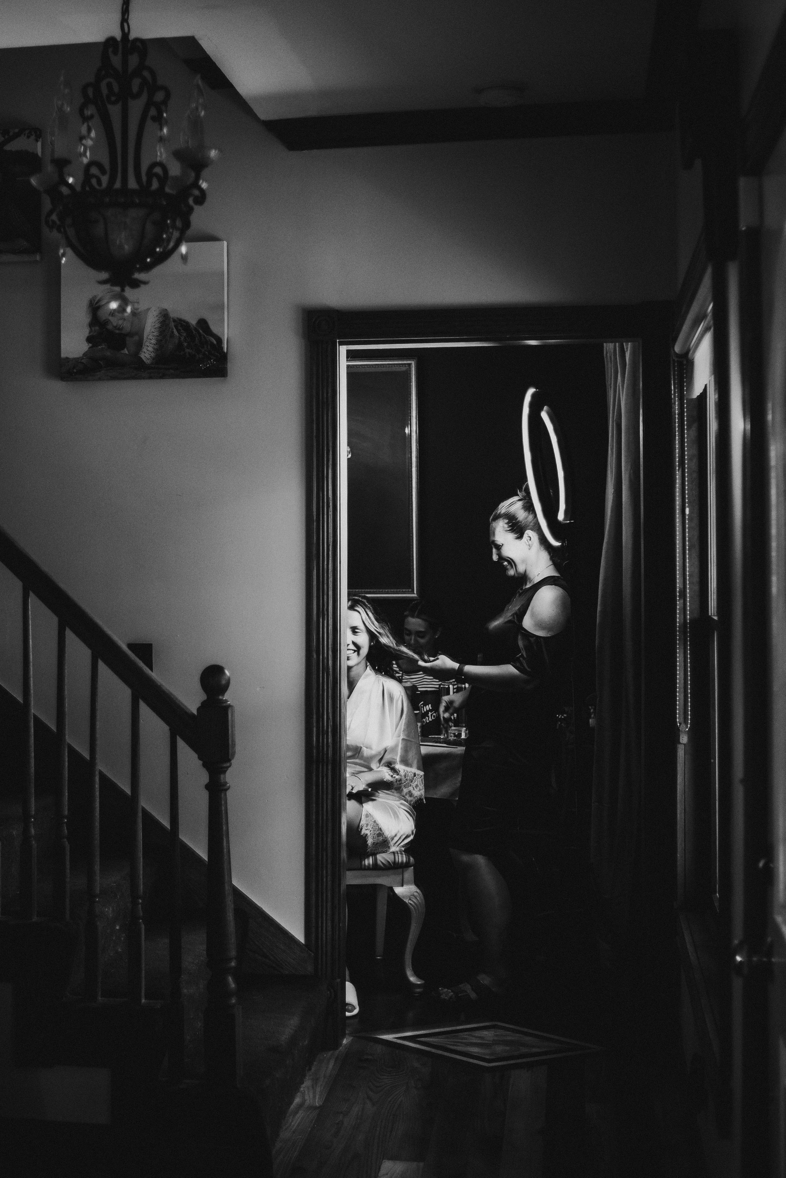 Black and white silhouette of someone getting ready in a dimly lit hallway.