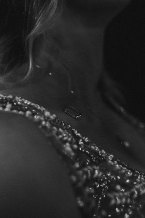 Artistic black and white macro shot of wedding dress beading with smoke or mist effect.