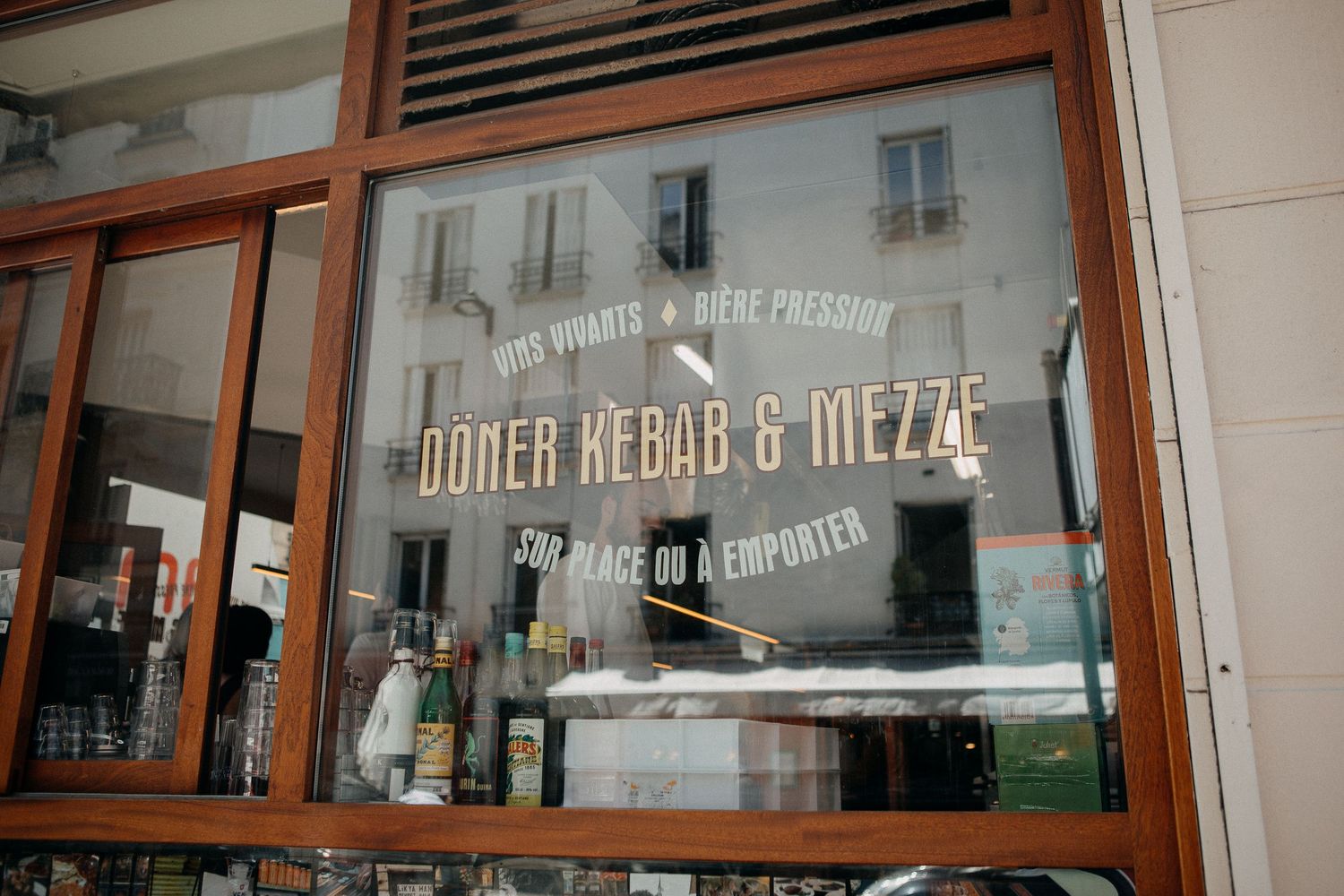 Doner Kebab & Mezze restaurant storefront sign on a glass window in France.