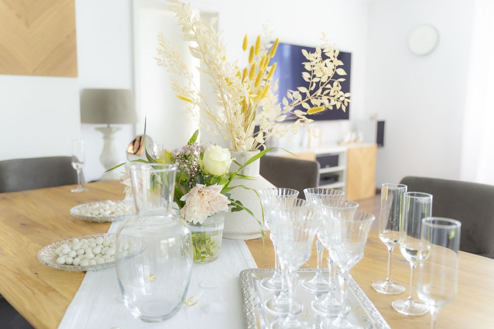 Elegant wedding reception table set with crystal glasses and dried floral centerpiece.