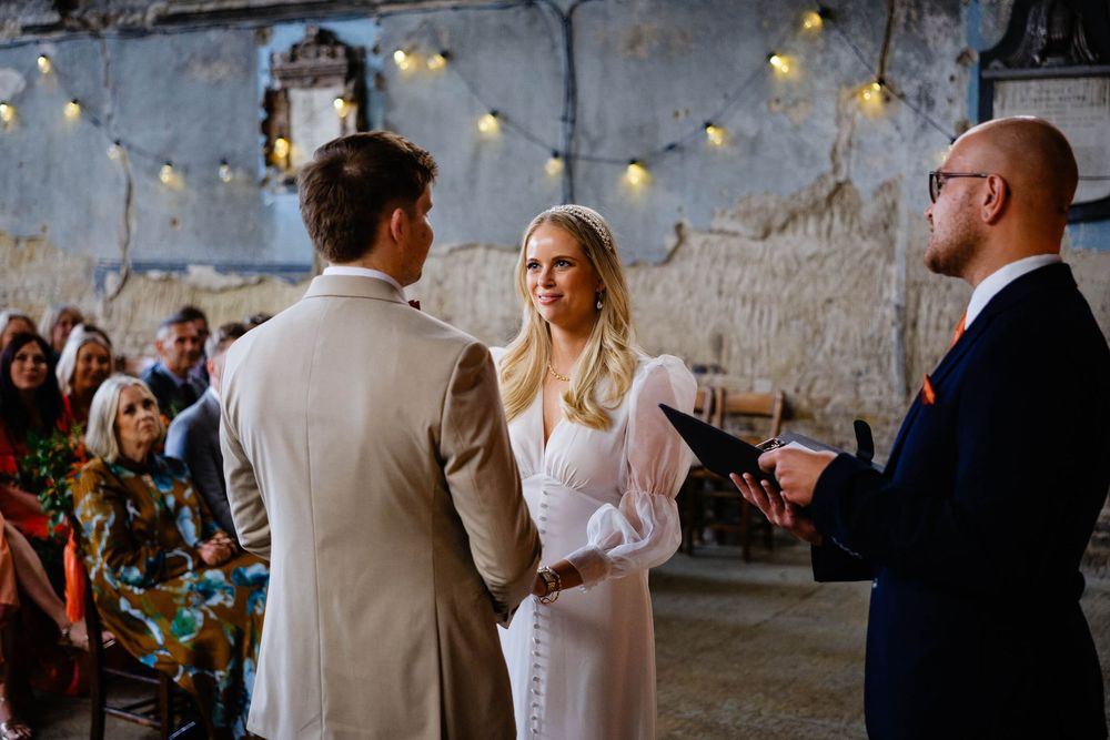 bride smiles at groom during wedding in the Asylum