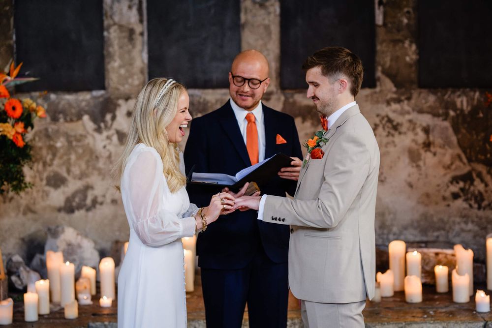 wedding ring exchange close up with candles behind