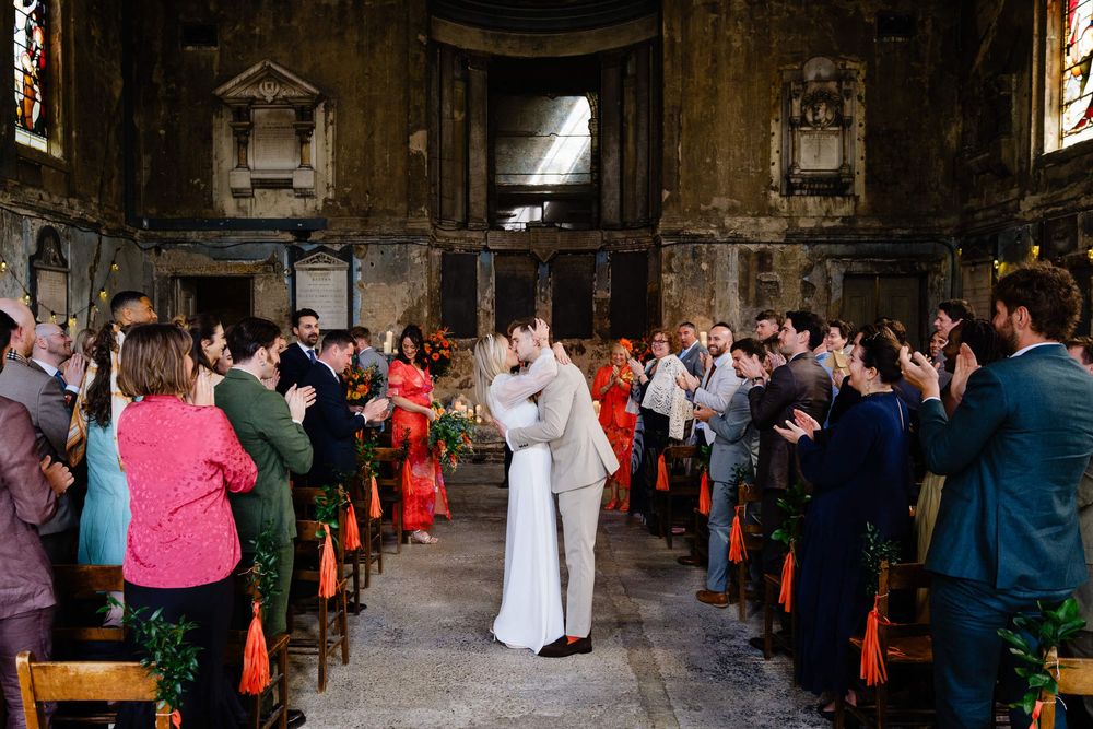 bride and groom kiss in the aisle at asylum chapel
