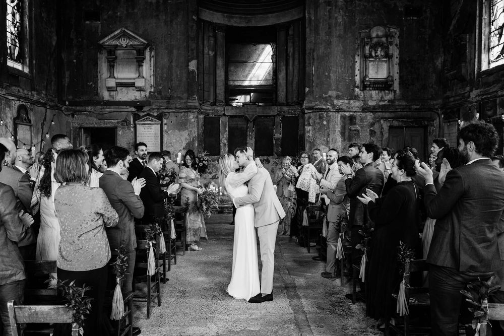 black and white photo of the bride and groom kissing in London asylum chapel