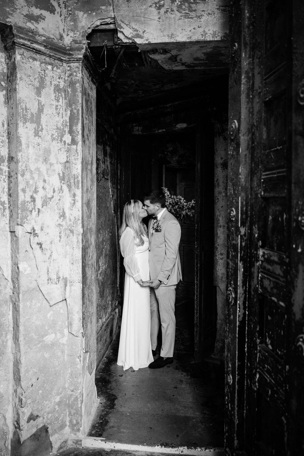 bride and groom kiss in doorway at the asylum