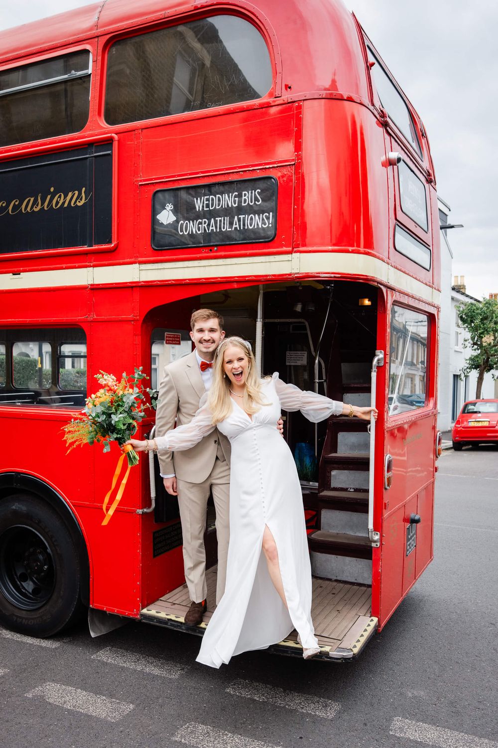 bride and groom on red London bus in London