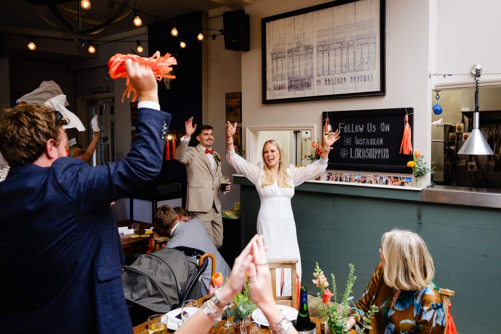 bride and groom cheering at the Lordship pub in London wedding
