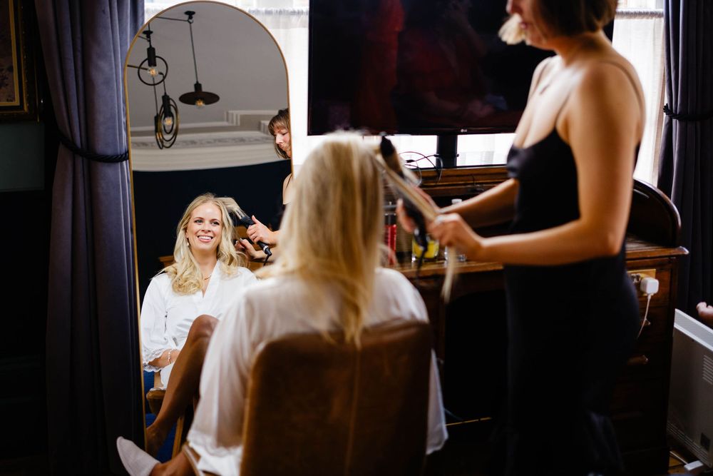 bride laughing in mirror at wedding