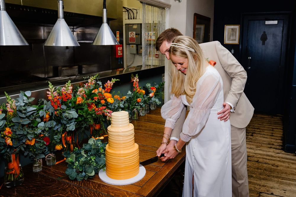 bride and groom cut the wedding cake at London pub wedding
