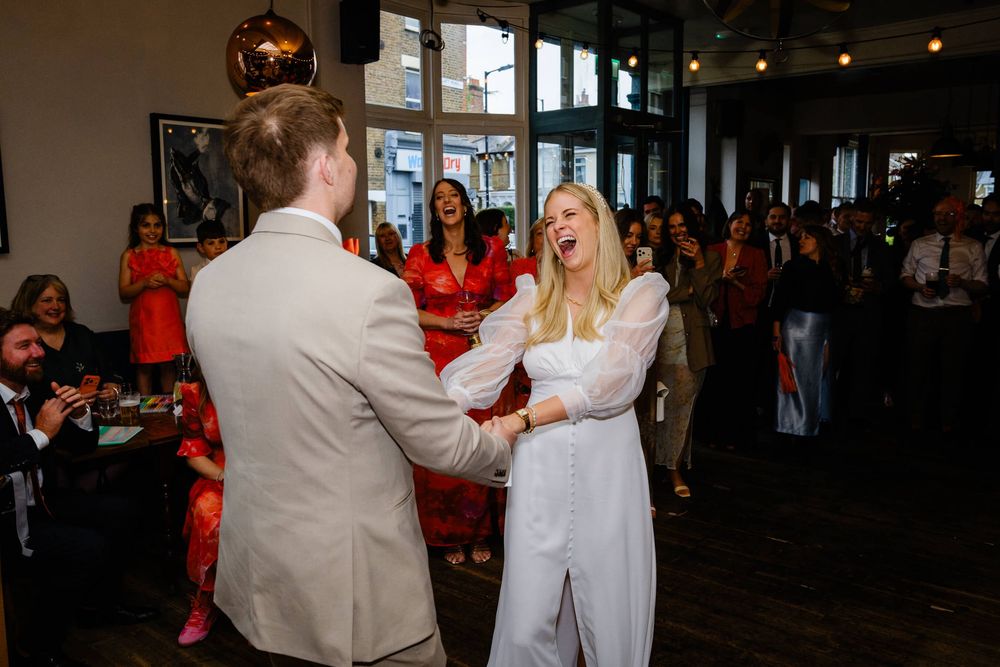 bride and groom holding hands while dancing at wedding in London