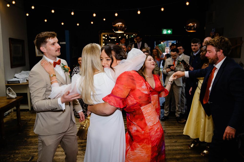 bride hugs friends on the dance floor at a wedding
