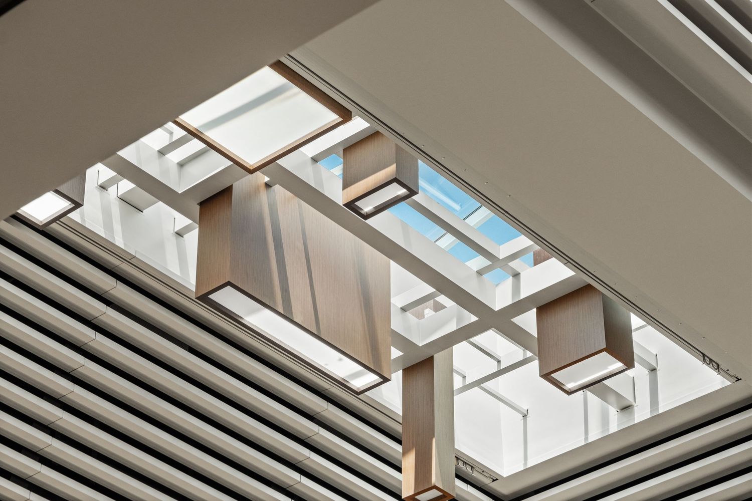 Modern architectural ceiling with geometric skylights creating dramatic lighting patterns.