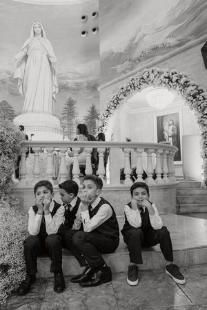 A creative series of black and white photos showing children's feet lined up in a row against a church wall.