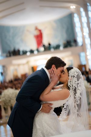 A romantic sequence of wedding photos showing a couple sharing their first kiss at the altar in an elegant indoor venue.