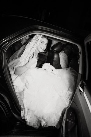 A sequence of black and white photos showing a bride in a puffy white wedding dress getting into a car.