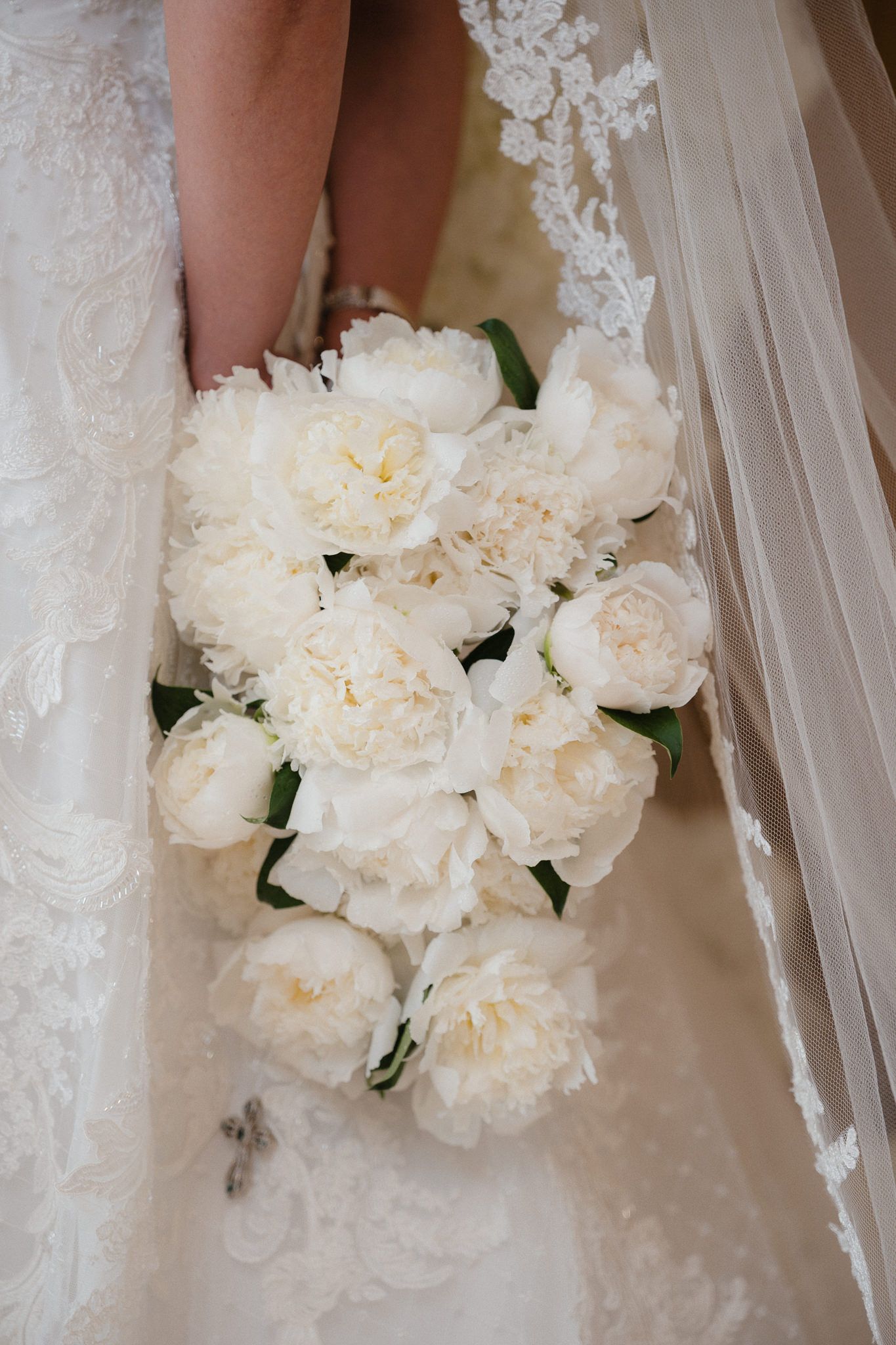 White peony bridal bouquet with delicate lace details from wedding dress.