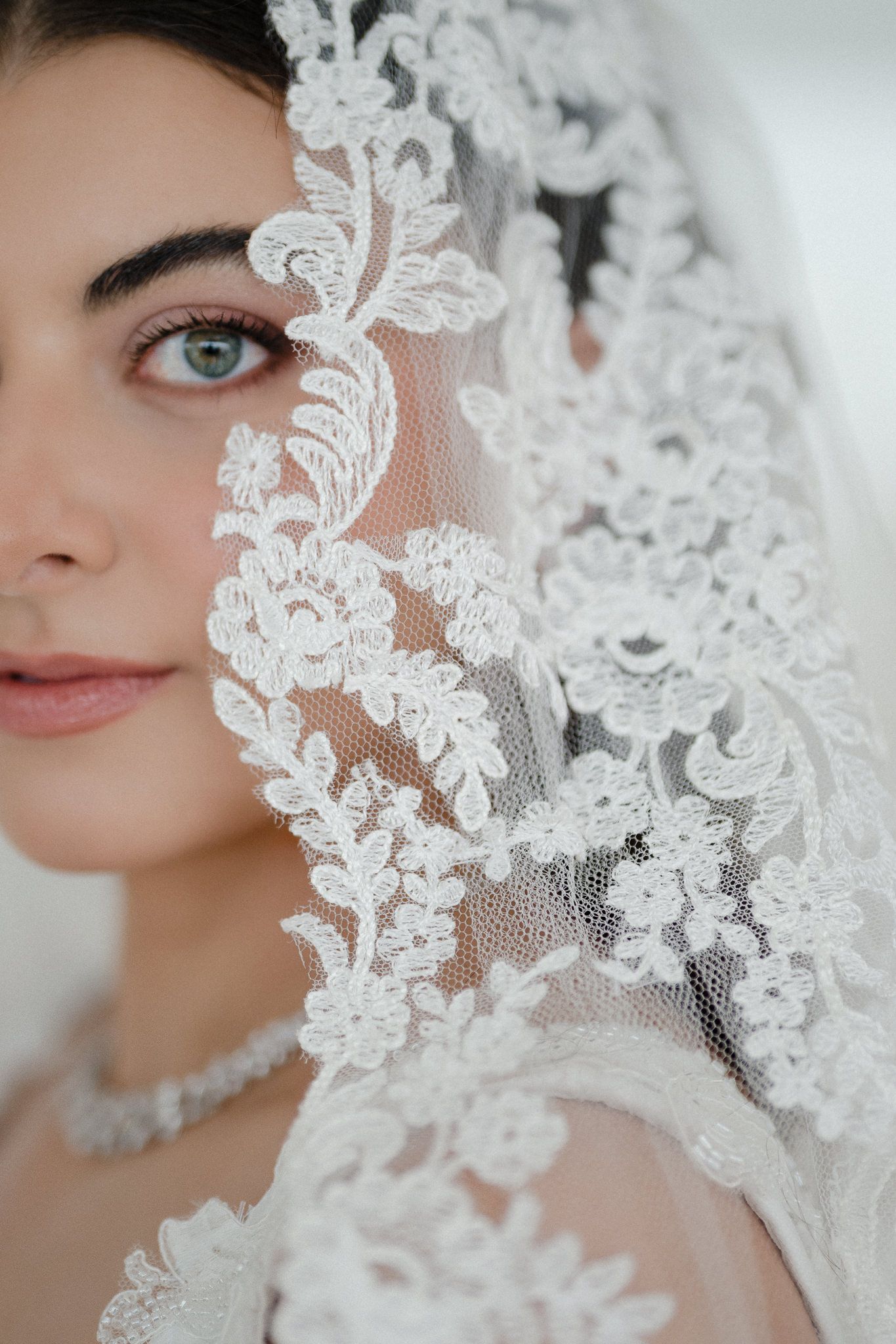 Close-up shots of delicate white lace veil details with floral patterns framing the frame.